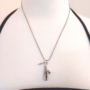 Silver trumpet pendant on a chain. The chain is marked, but the trumpet isn't.